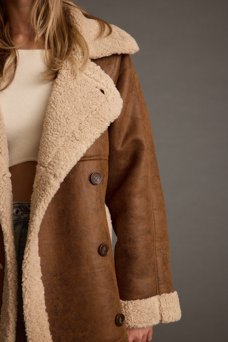 Lifestyle shot of the brown jacket styled for day-to-night versatility.